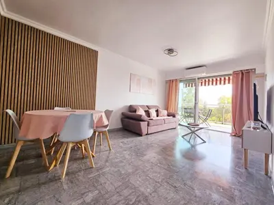 a living room with a table and a couch at T2 Vue Mer avec Grande Terrasse & Parking 4 min Plage - SpiritofFamily06 in Cagnes-sur-Mer