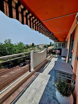a balcony with an umbrella and a deck with a view at T2 Vue Mer avec Grande Terrasse & Parking 4 min Plage - SpiritofFamily06 in Cagnes-sur-Mer