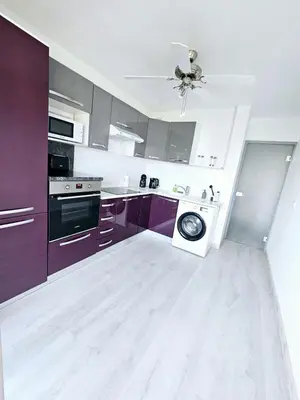 a kitchen with purple cabinets and a washer at T2 Vue Mer avec Grande Terrasse & Parking 4 min Plage - SpiritofFamily06 in Cagnes-sur-Mer