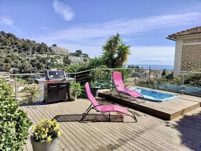 a deck with two pink chairs and a swimming pool at Nice Signature Bellet in Nice