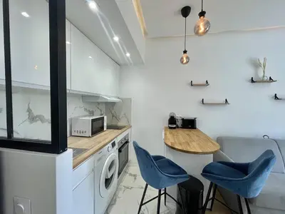 a kitchen with a washing machine and a table and chairs at Nice Signature Andrioli in Nice