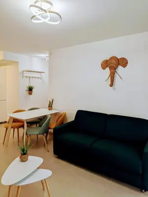 a living room with a blue couch and a table at Appartement neuf T2 calme avec terrasse - Proche Marché Liberation in Nice