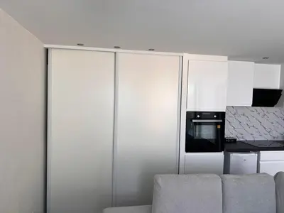 a kitchen with white cabinets and a microwave at Amoremio studio Saint Laurent du Var in Saint-Laurent-du-Var