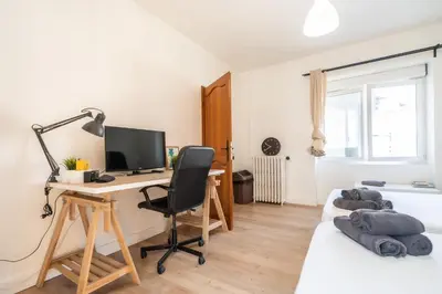 a bedroom with a desk with a computer and a bed at Guest House La Niçoise in Nice
