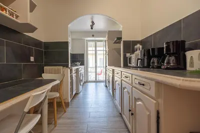 a kitchen with white cabinets and a large mirror at Guest House La Niçoise in Nice