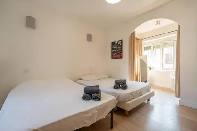 two twin beds in a room with a mirror at Guest House La Niçoise in Nice