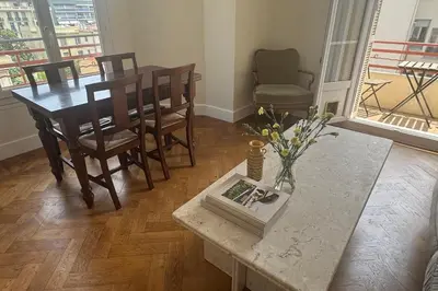 a living room with a table with a vase of flowers at Top Floor Central Steps from the sea in Nice