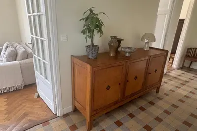 a wooden cabinet with a potted plant on top of it at Top Floor Central Steps from the sea in Nice