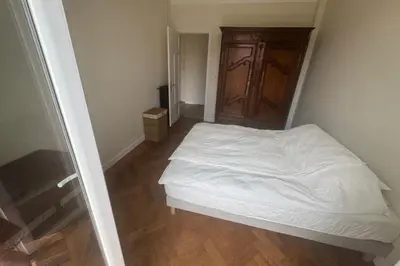 a small bedroom with a white bed and a wooden floor at Top Floor Central Steps from the sea in Nice