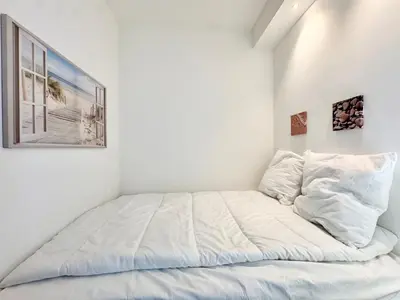 a bed in a room with white walls at Le Milord - Easy Home Booking in Nice