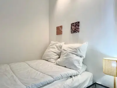 a bed with white sheets on it in a room at Le Milord - Easy Home Booking in Nice