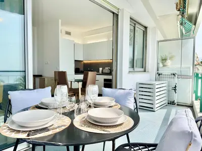 a dining room with a black table and chairs at Le Milord - Easy Home Booking in Nice