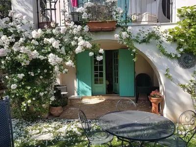 a patio with a table and chairs and flowers at Villa, Villefranche-sur-mer, Pool, Tennis Court, in Villefranche-sur-Mer