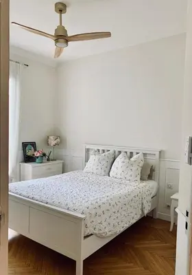 a white bedroom with a bed and a ceiling fan at Cocon chic au cœur de la ville in Nice