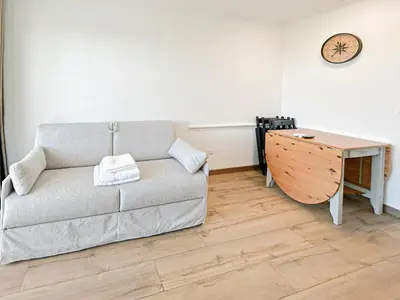 a living room with a couch and a desk at Élégance Azuréenne - piscine et parking in Villefranche-sur-Mer
