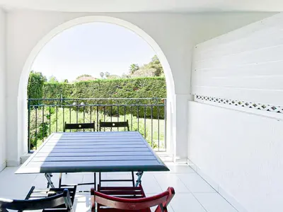 a table and chairs on a balcony with a window at Élégance Azuréenne - piscine et parking in Villefranche-sur-Mer