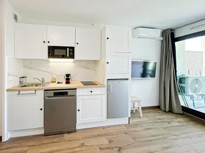 a kitchen with white cabinets and a sink at Élégance Azuréenne - piscine et parking in Villefranche-sur-Mer