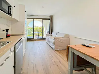 a kitchen and living room with a couch and a table at Élégance Azuréenne - piscine et parking in Villefranche-sur-Mer