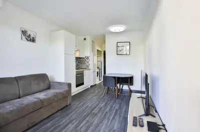 a living room with a couch and a table at Superbe 2 pièce tout confort - AC, piscine, Park in Villefranche-sur-Mer