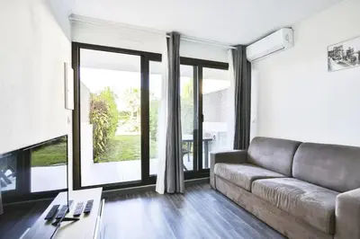 a living room with a couch and large windows at Superbe 2 pièce tout confort - AC, piscine, Park in Villefranche-sur-Mer