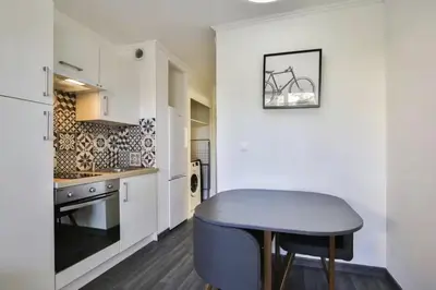 a kitchen with a stool and a table in a room at Superbe 2 pièce tout confort - AC, piscine, Park in Villefranche-sur-Mer