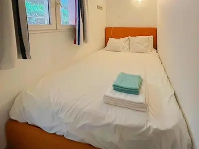 a small bed with white sheets and towels on it at Ange Gardien - AC, Parking, Piscine in Villefranche-sur-Mer
