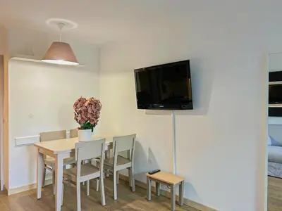 a dining room table with chairs and a tv on a wall at Ange Gardien - AC, Parking, Piscine in Villefranche-sur-Mer