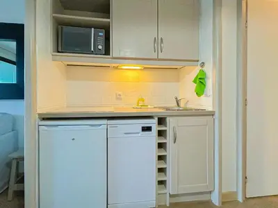 a small kitchen with a sink and a microwave at Ange Gardien - AC, Parking, Piscine in Villefranche-sur-Mer