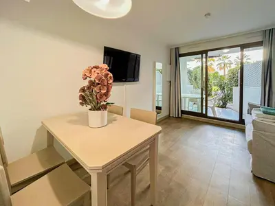 a living room with a table with a vase of flowers on it at Ange Gardien - AC, Parking, Piscine in Villefranche-sur-Mer