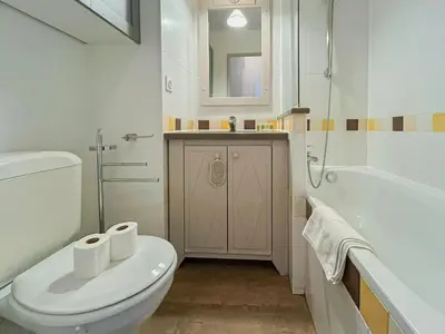 a bathroom with a toilet and a tub and a sink at Ange Gardien - AC, Parking, Piscine in Villefranche-sur-Mer
