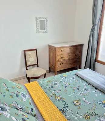 a bedroom with a bed and a dresser and a chair at L'Appart by la Maïoun Guesthouse in Nice