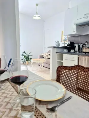a table with a plate and a glass of wine at L'Appart by la Maïoun Guesthouse in Nice