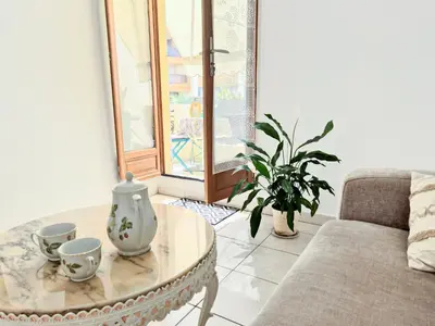 a living room with a table and a couch at L'Appart by la Maïoun Guesthouse in Nice