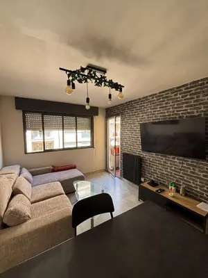 a living room with a couch and a flat screen tv at Charmant 2 pièce à 2min de la mer in Nice