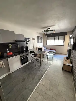 a kitchen and living room with a table and a couch at Charmant 2 pièce à 2min de la mer in Nice