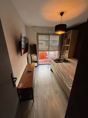 a bedroom with a bed and a table and a window at Charmant 2 pièce à 2min de la mer in Nice