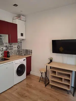 a kitchen with a washing machine and a table at Studio 1 pièce in Nice
