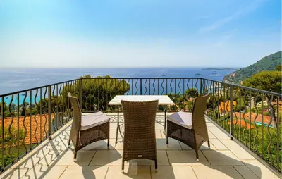 a balcony with a table and chairs and the ocean at Beautiful Home In Eze in Èze