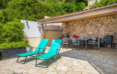 a patio with turquoise chairs and a table at Beautiful Home In Eze in Èze