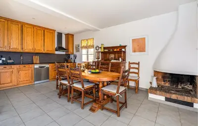 a kitchen with a table and chairs and a fireplace at Beautiful Home In Eze in Èze