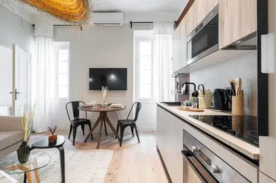 a kitchen and living room with a table and chairs at 5 BEAUMONT - Magnifique 3P au style boheme - Quartier Garibaldi in Nice