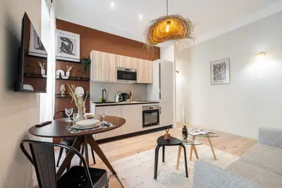 a living room with a table and a kitchen at 5 BEAUMONT - Magnifique 3P au style boheme - Quartier Garibaldi in Nice
