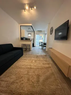 a living room with a couch and a flat screen tv at Studio cosy avec balcon - Tramway au pied, proche centre in Nice