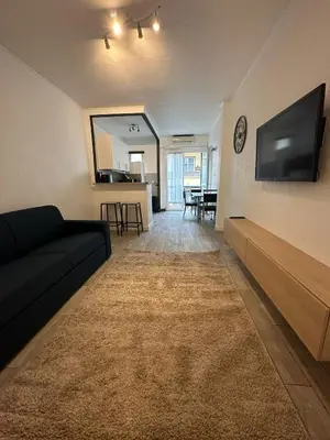 a living room with a couch and a flat screen tv at Studio cosy avec balcon - Tramway au pied, proche centre in Nice