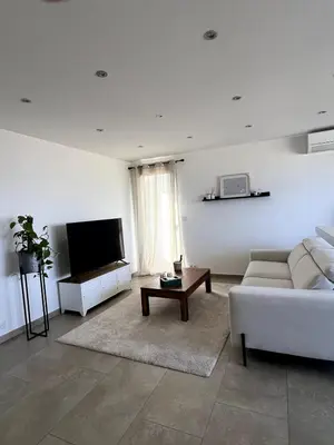 a living room with a couch and a tv at Lea's cozy nest with a sea-mountain view in Saint-Laurent-du-Var