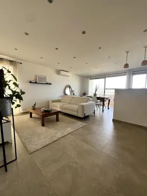 a living room with a couch and a table at Lea's cozy nest with a sea-mountain view in Saint-Laurent-du-Var