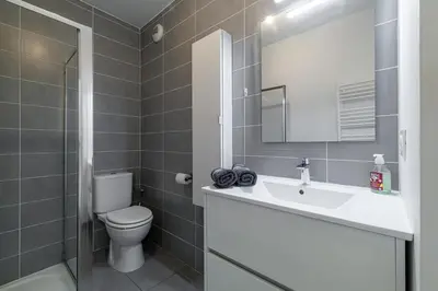 a kitchen with white cabinets and a sink at Charmant 2 pièces lumineux Quartier du Port in Nice