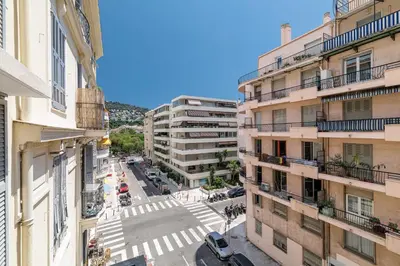 a bedroom with a bed and a large window at Charmant 2 pièces lumineux Quartier du Port in Nice