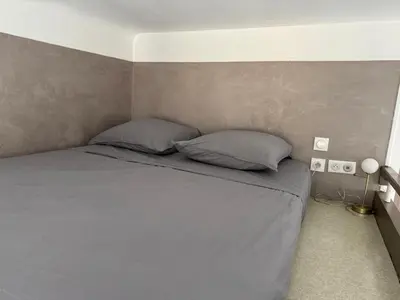 a bedroom with a gray bed with two pillows at Appartement - Nice - Quartier du Port in Nice