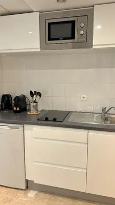 a white kitchen with a sink and a microwave at Studio 4 Carré d'Or in Nice